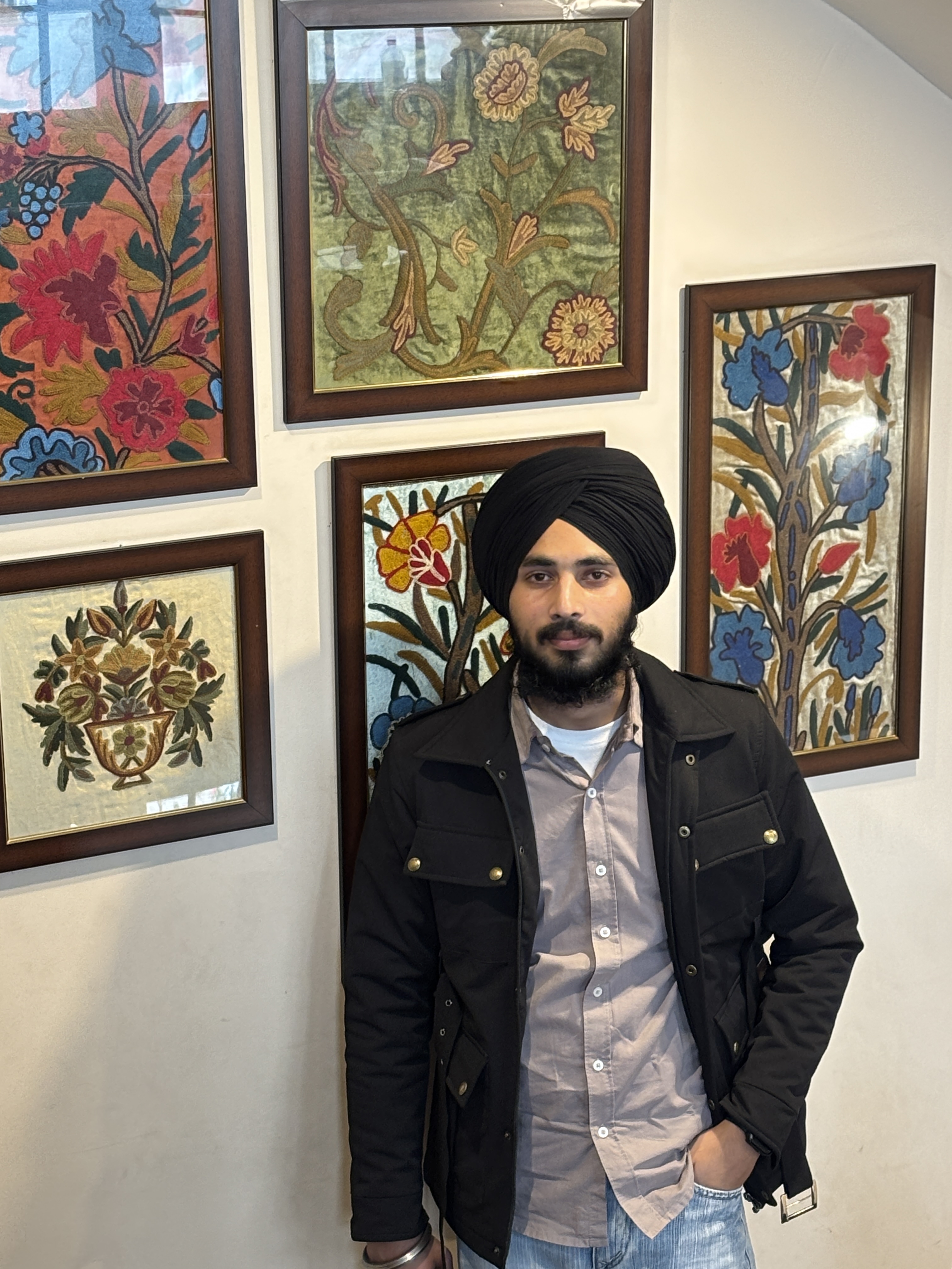 Sahilpreet Singh standing in front of framed artwork